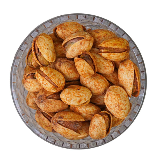 Pistachios in a metal bowl on a white background