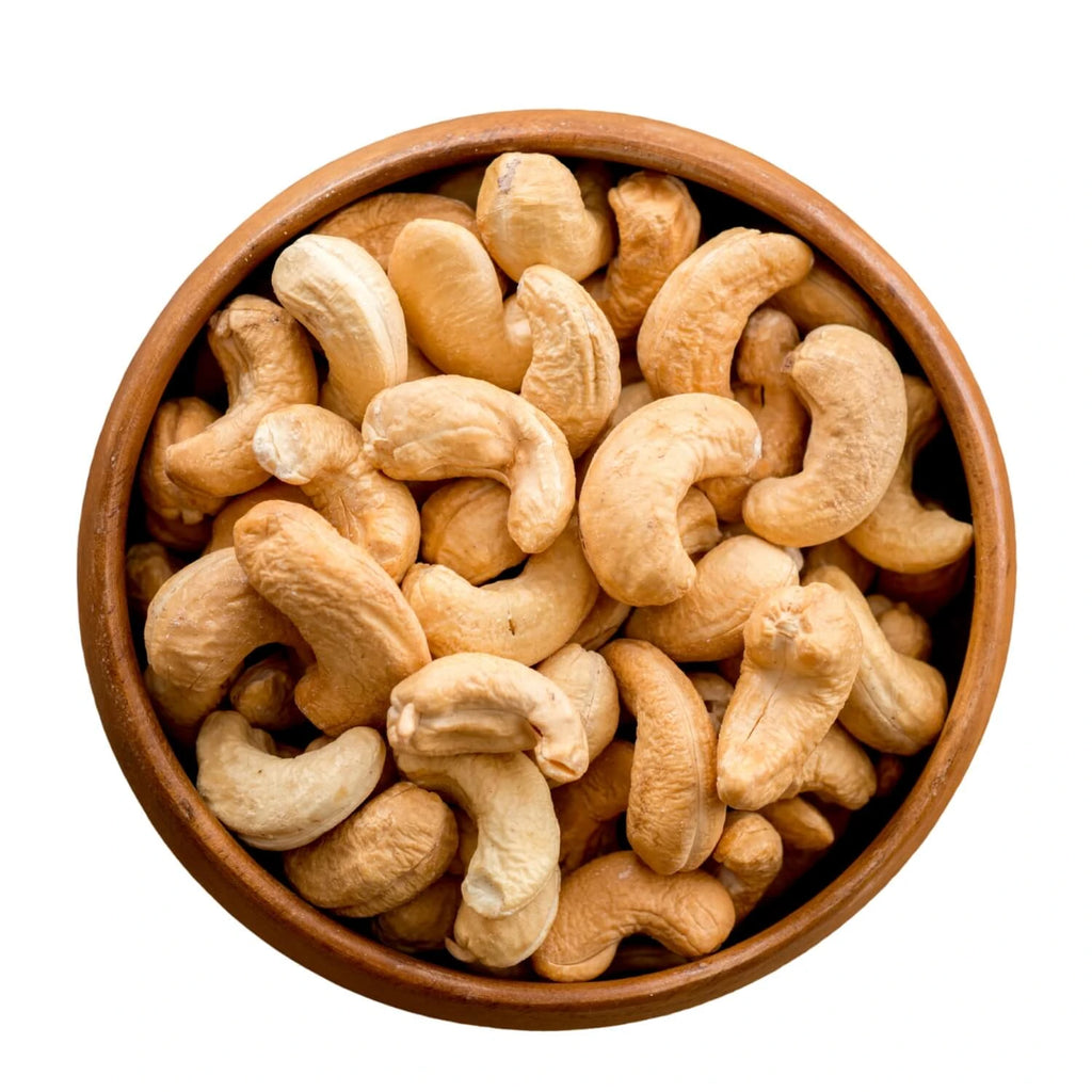 roasted cashews piled in a round wooden bowl.