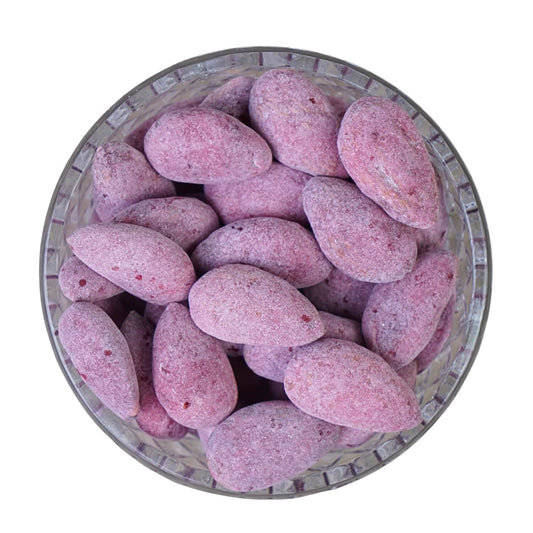 Purple almonds in a glass bowl on a white background