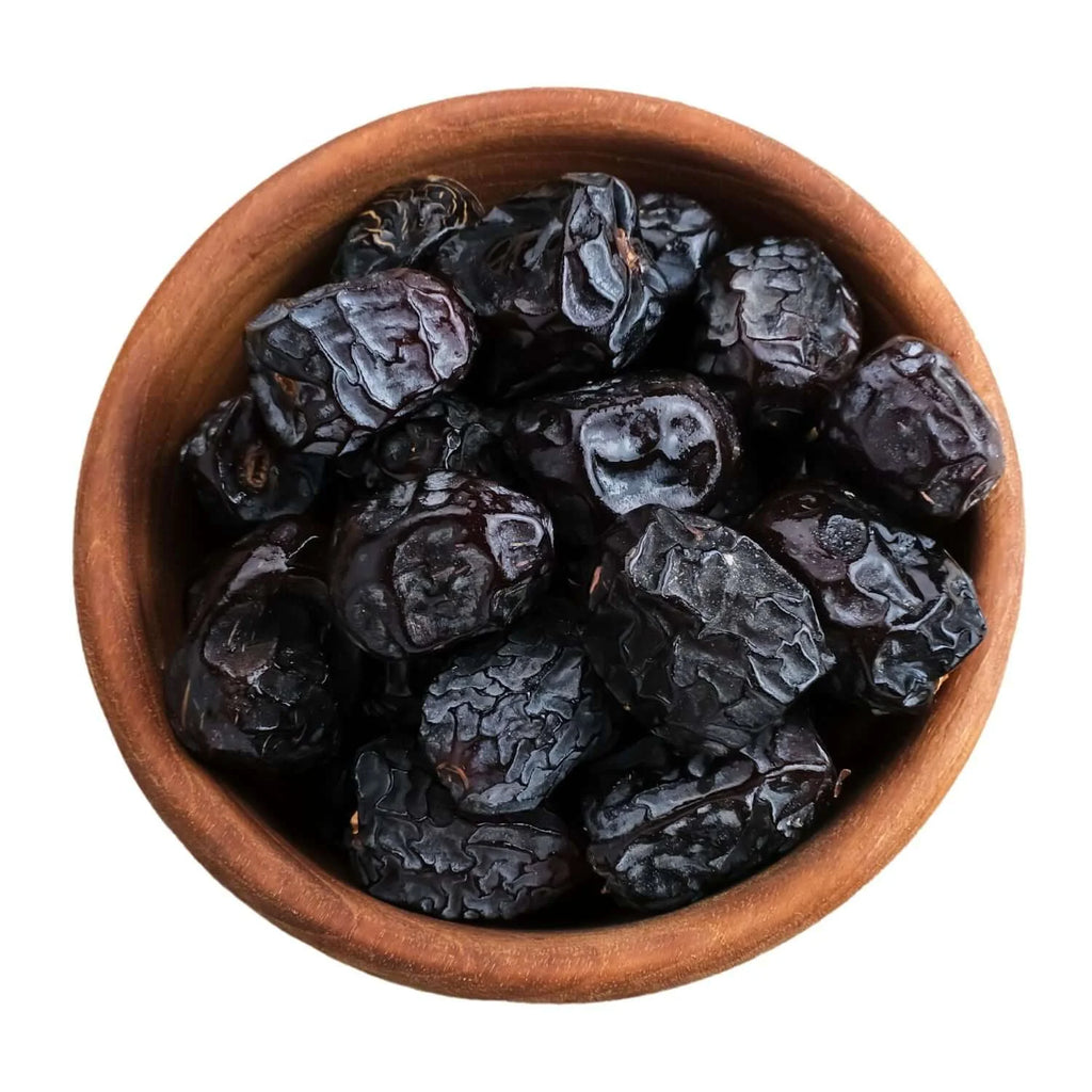 Wooden bowl filled with ajwa dates