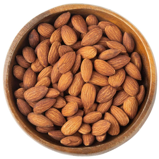Wooden bowl filled with almonds on a white background