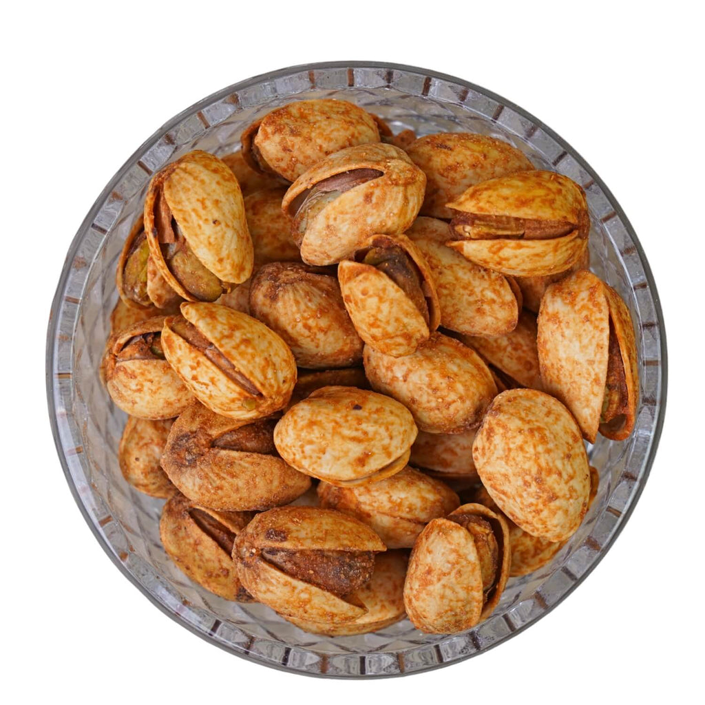 Pistachios in a metal bowl on a white background