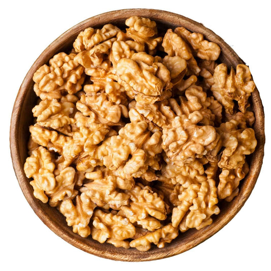 Wooden bowl filled with walnuts on a white background