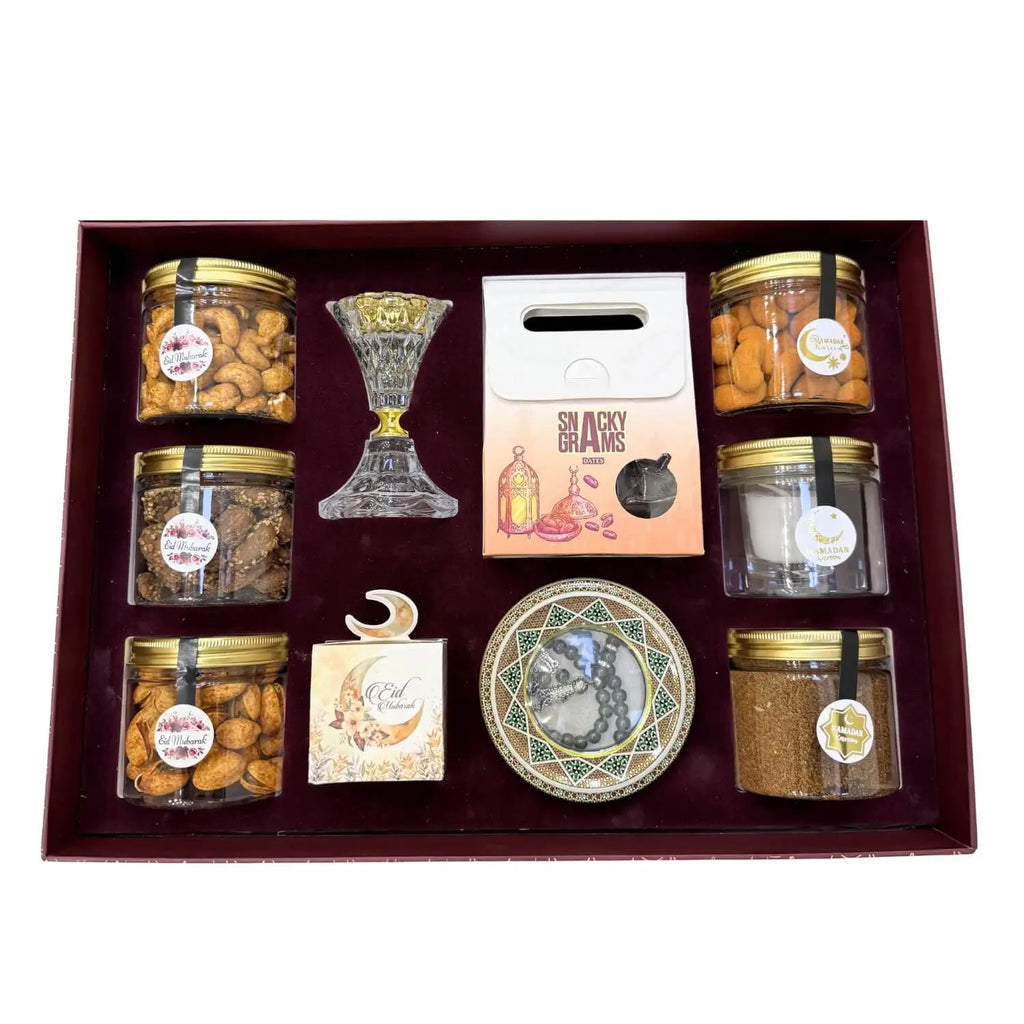 Gift set with jars of snacks, a candle, and decorative items on a white background