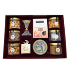 Gift set with jars of snacks, a candle, and decorative items on a white background