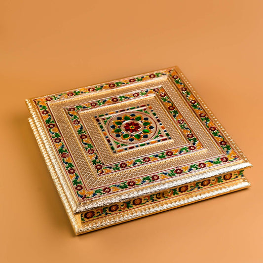 Decorative square box with intricate patterns on a beige background