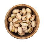salted pistachios in a round wooden bowl
