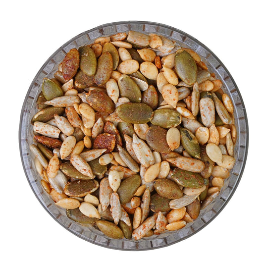 Assorted seeds in a metal bowl on a white background